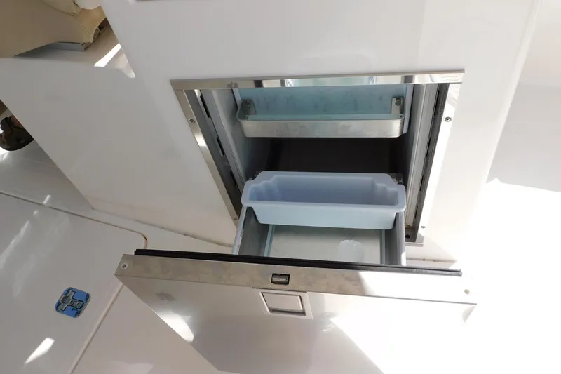Slide: The Image of Open storage compartment on 2016 Pursuit DC 325 Dual Console boat. - 27
