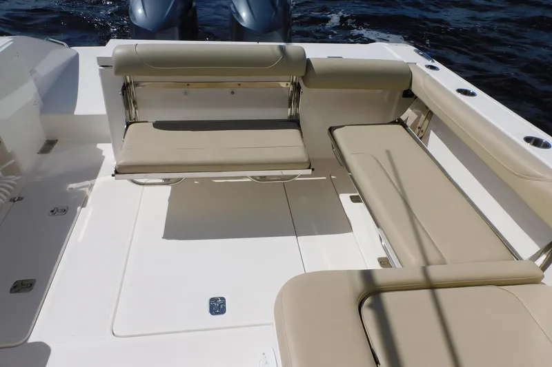 Slide: The Image of 2016 Pursuit DC 325 Dual Console boat interior with beige seating and twin engines. - 29