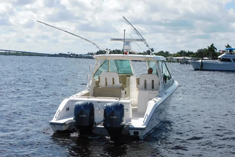 Slide: The Image of 2016 Pursuit DC 325 Dual Console boat on water, featuring twin engines. - 3