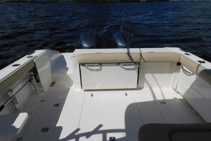 Slide: The Image of 2016 Pursuit DC 325 Dual Console boat interior with seating and storage, on water. - 32