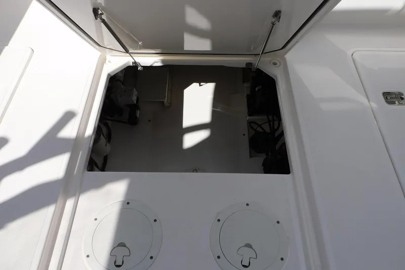 Slide: The Image of Open storage compartment on a 2016 Pursuit DC 325 Dual Console boat. - 33