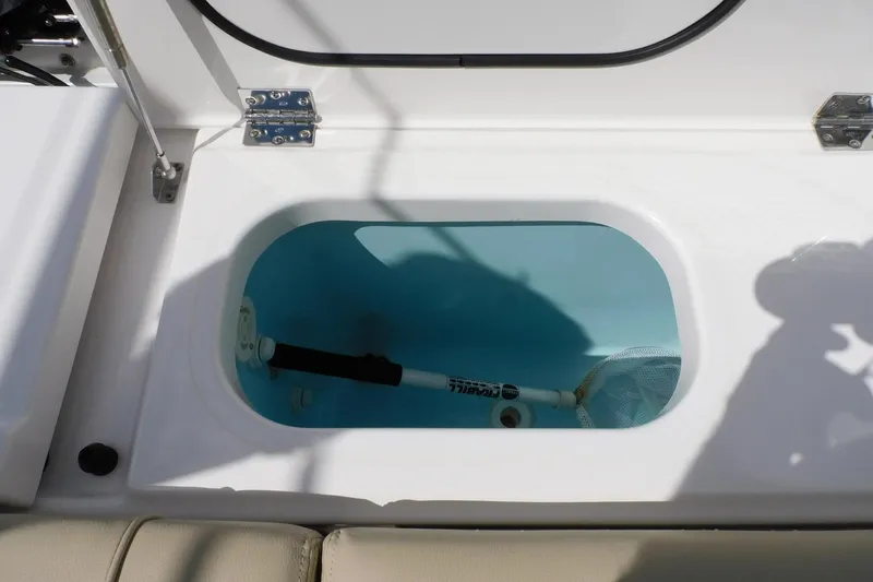 Slide: The Image of Livewell compartment on 2016 Pursuit DC 325 Dual Console boat, featuring a net and water. - 36