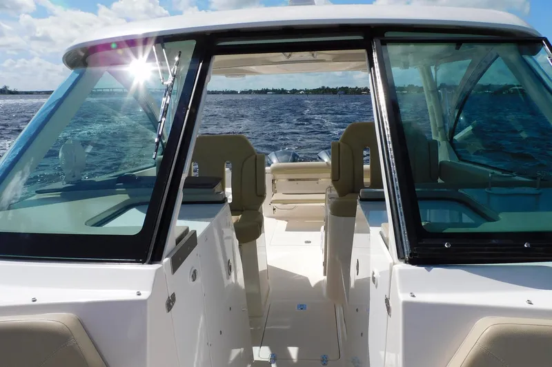 Slide: The Image of 2016 Pursuit DC 325 Dual Console boat interior with ocean view and sunlight reflection. - 9