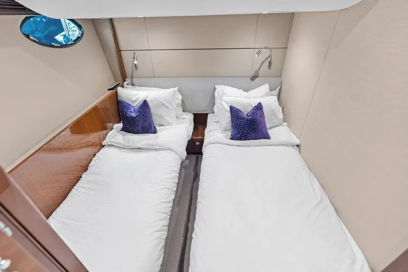 Slide: The Image of Twin beds in a 2016 Princess 60 Flybridge Motor Yacht cabin with purple accent pillows. - 47