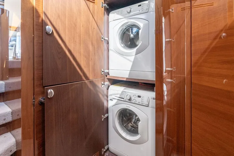 Slide: The Image of Laundry area with stacked washer and dryer in 2016 Princess 60 Flybridge Yacht. - 62