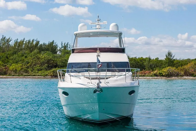 Slide: The Image of 2016 Princess 60 Flybridge Motor Yacht on serene water, lush greenery background. - 8