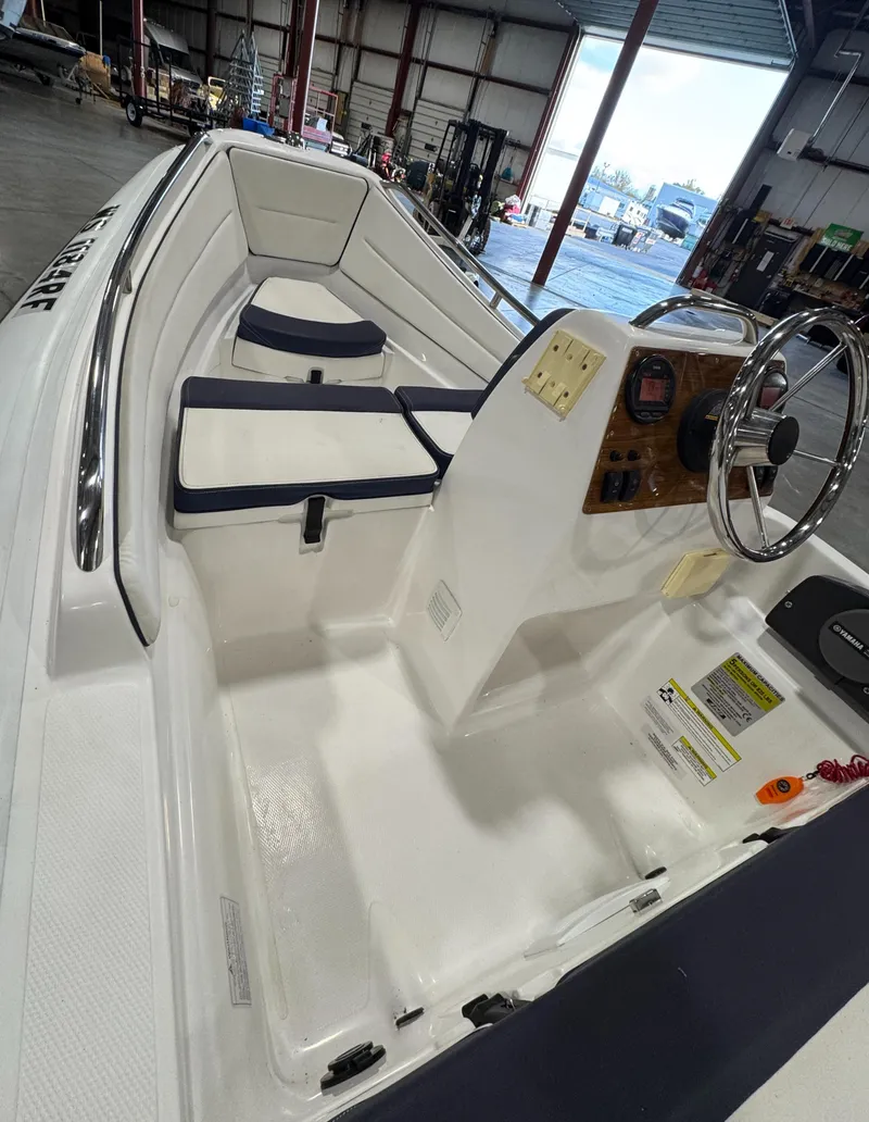 Slide: The Image of 2018 AB Inflatables Nautilus 12 DLX boat interior with steering console in a warehouse. - 10