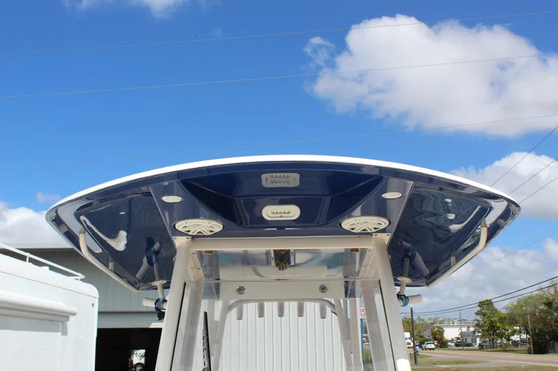 Slide: The Image of 2019 Cobia 301 Center Console boat with blue T-top under a clear sky. - 17