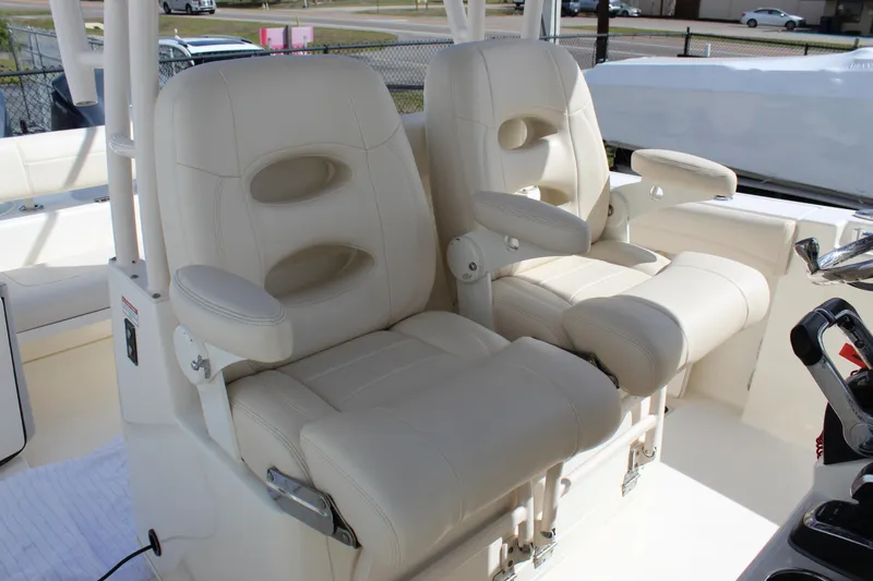Slide: The Image of 2019 Cobia 301 Center Console boat with luxurious white captain's chairs. - 25