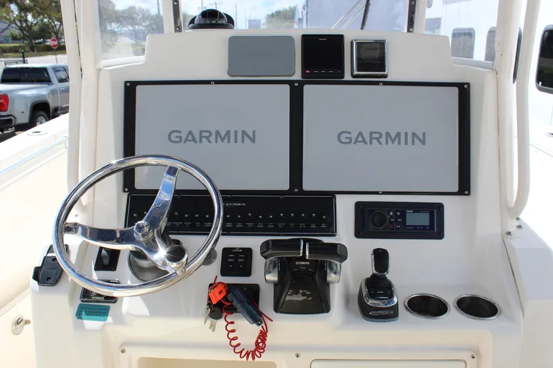 Slide: The Image of 2019 Cobia 301 Center Console helm with Garmin displays and steering wheel. - 26