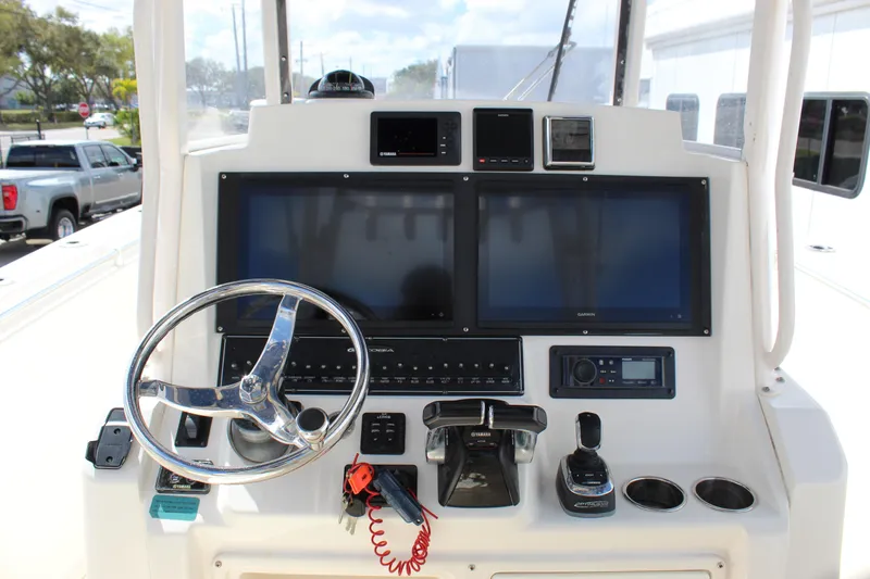 Slide: The Image of 2019 Cobia 301 Center Console helm with dual screens and steering wheel. - 27