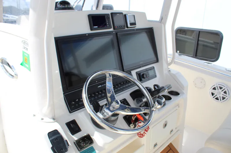 Slide: The Image of 2019 Cobia 301 Center Console helm with dual screens and steering wheel. - 28