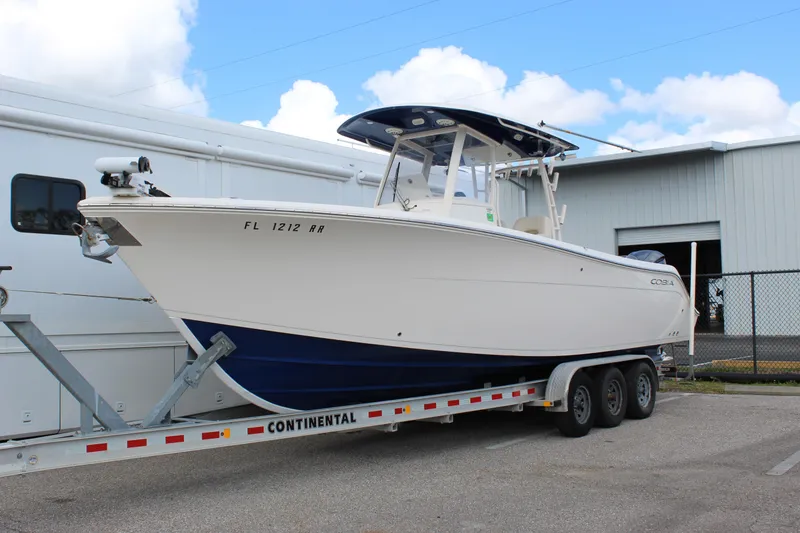 Slide: The Image of 2019 Cobia 301 Center Console boat on trailer, parked outdoors. - 3