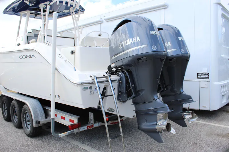 Slide: The Image of 2019 Cobia 301 Center Console boat with dual Yamaha outboard engines on a trailer. - 7