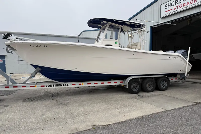The Image of 2019 Cobia 301 Center Console boat on trailer at storage facility. - 1