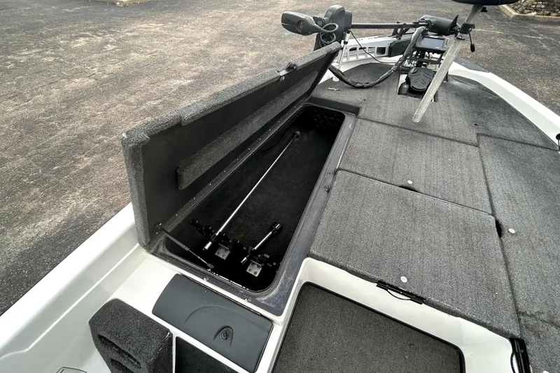 Slide: The Image of 2014 Skeeter TZX195 boat interior with open storage compartment and fishing rod holders. - 11