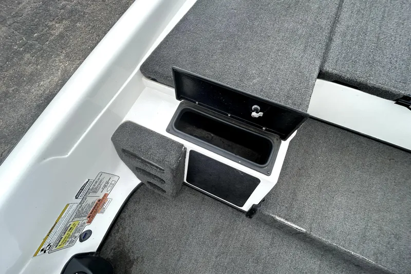 Slide: The Image of 2014 Skeeter TZX195 boat storage compartment with open lid, showing interior space. - 21
