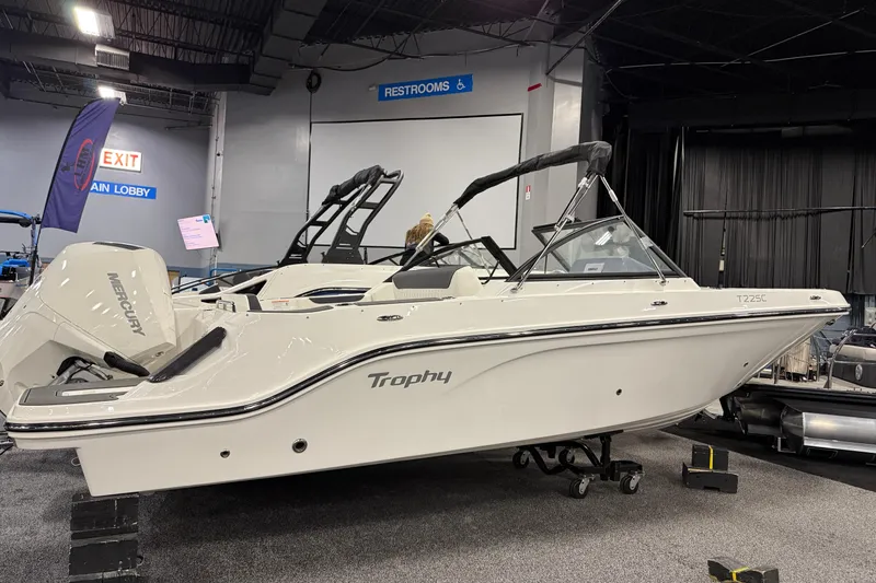 The Image of 2026 Bayliner Trophy T22SC boat displayed indoors with Mercury engine. - 0