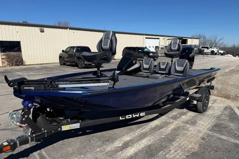 Slide: The Image of 2026 Lowe Stinger 175C fishing boat on trailer, parked outdoors under clear blue sky. - 1