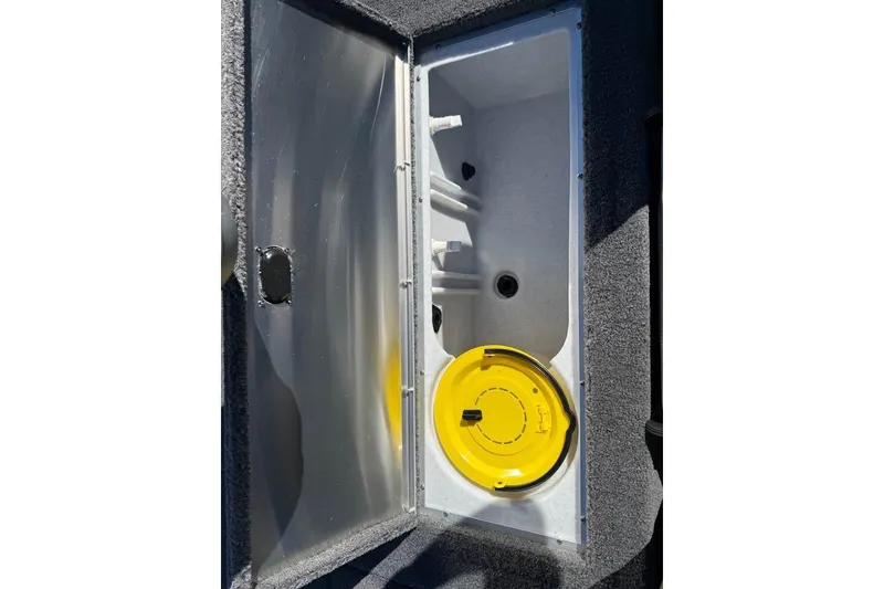 Slide: The Image of Open storage compartment in 2026 Lowe Stinger 175C boat, featuring a yellow lid. - 16