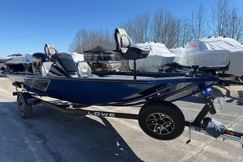 Slide: The Image of 2026 Lowe Stinger 175C boat on trailer, parked outdoors under clear blue sky. - 3