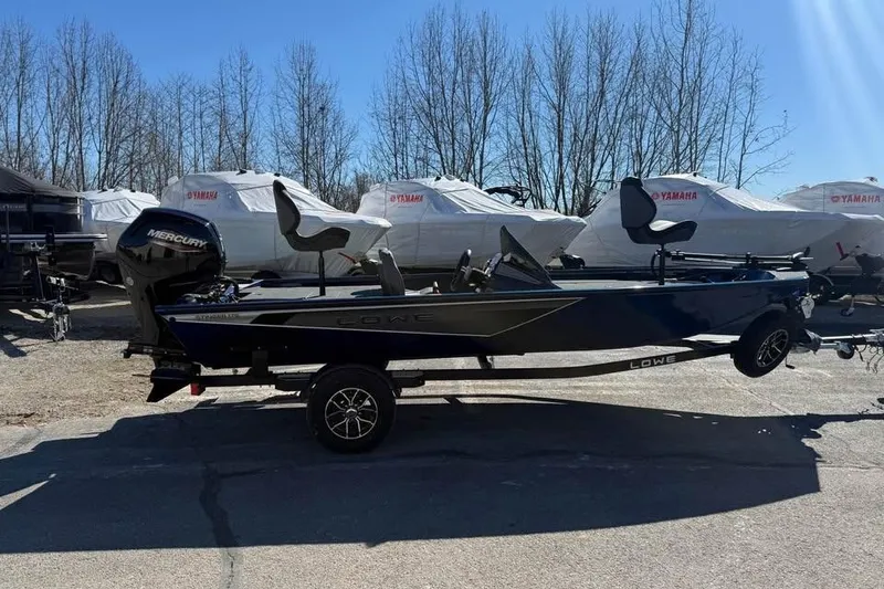 Slide: The Image of 2026 Lowe Stinger 175C boat with Mercury engine, parked outdoors on a trailer. - 7