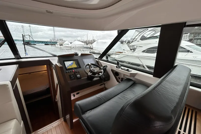 Slide: The Image of 2016 Tiara Yachts C44 Coupe helm with navigation display and leather seating. - 12