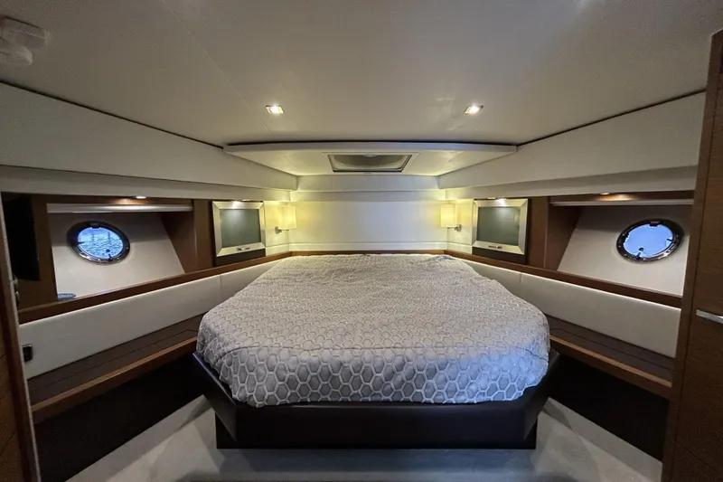 Slide: The Image of Luxurious bedroom interior of 2016 Tiara Yachts C44 Coupe with elegant bedding and porthole windows. - 14