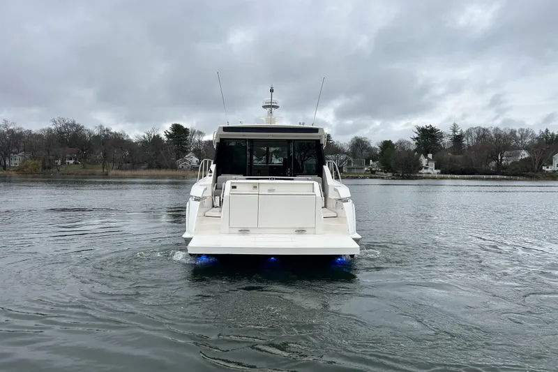 Slide: The Image of 2016 Tiara Yachts C44 Coupe on calm water, rear view with overcast sky. - 3