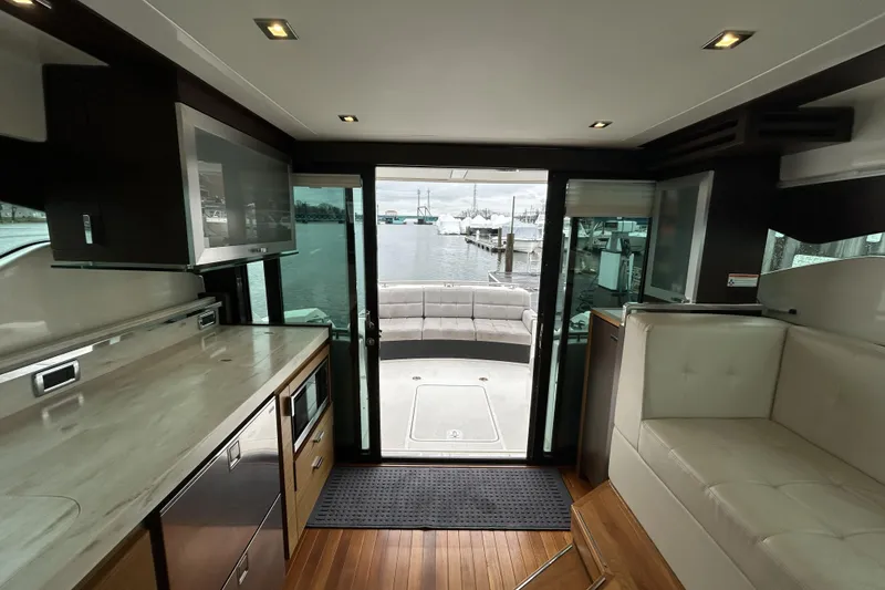 Slide: The Image of Interior view of 2016 Tiara Yachts C44 Coupe, featuring modern kitchen and seating area. - 6