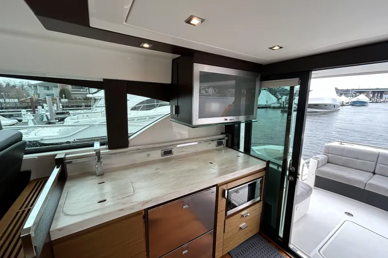 Slide: The Image of Interior of 2016 Tiara Yachts C44 Coupe with modern kitchen and marina view. - 8