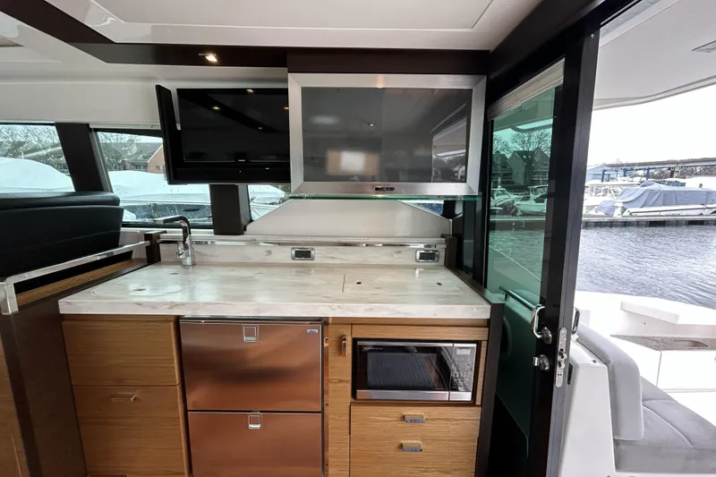 Slide: The Image of Interior of 2016 Tiara Yachts C44 Coupe featuring modern kitchen amenities and waterfront view. - 9