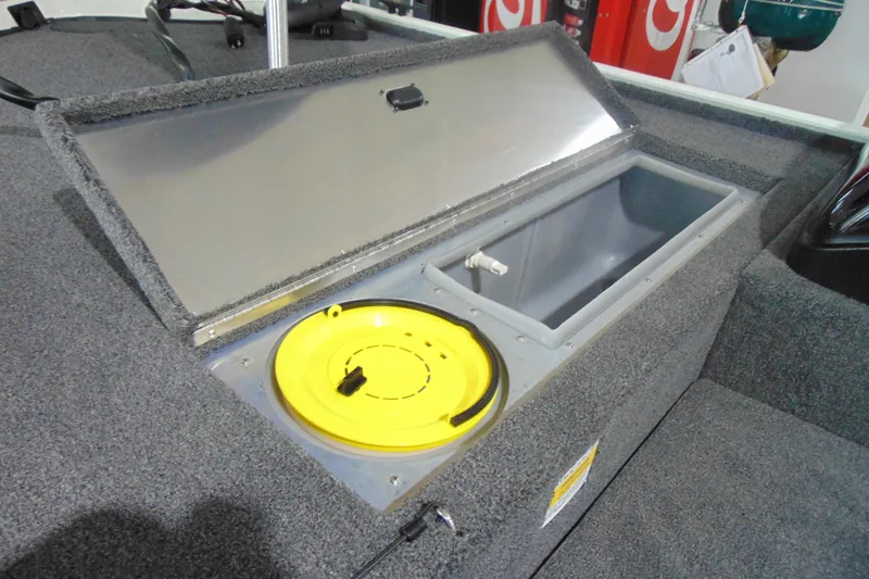 Slide: The Image of 2026 Crestliner 1600 Storm boat storage compartment with open lid and yellow hatch. - 4