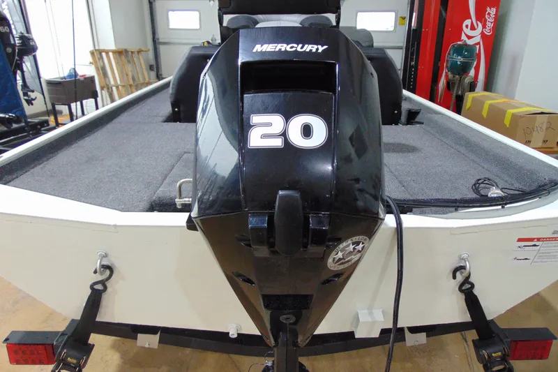 Slide: The Image of 2026 Crestliner 1600 Storm boat with Mercury 20 horsepower engine in a garage setting. - 7