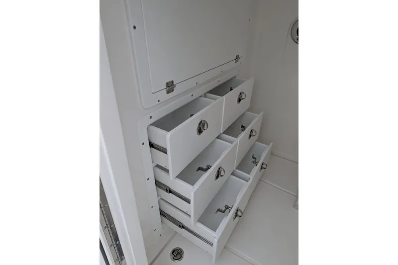 Slide: The Image of Storage drawers inside 2026 Caymas 30 CT boat, featuring sleek white design and metal handles. - 10