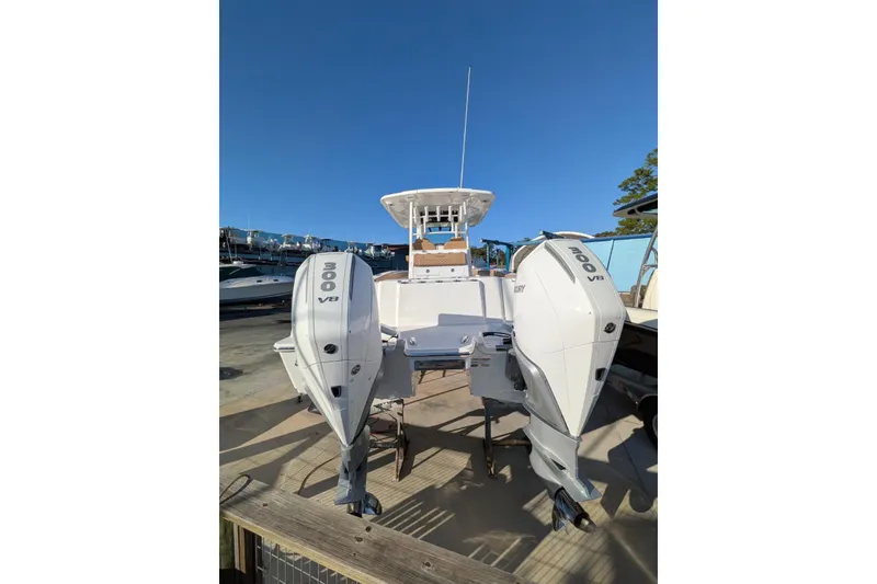 Slide: The Image of 2026 Caymas 30 CT boat with dual 300 V8 engines, docked under clear blue sky. - 5