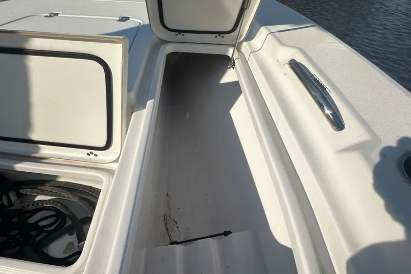 Slide: The Image of 2020 Sportsman Masters 247 Bay Boat storage compartments, open and empty, with visible cleat. - 30