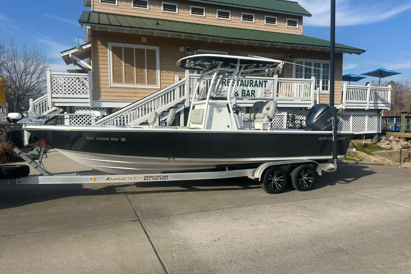 Slide: The Image of 2020 Sportsman Masters 247 Bay Boat on trailer, parked near a restaurant. - 5