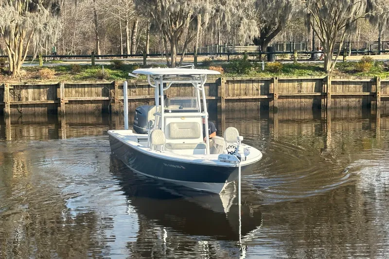 Slide: The Image of 2020 Sportsman Masters 247 Bay Boat cruising on a calm river near a wooden dock. - 8