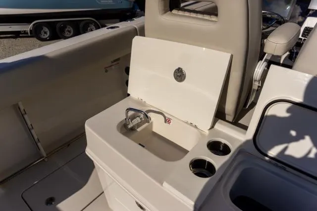 Slide: The Image of 2024 Sailfish 312 CC boat interior with open storage compartment and cup holders. - 16