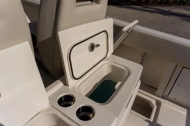 Slide: The Image of 2024 Sailfish 312 CC boat interior with storage compartment and cup holders. - 17