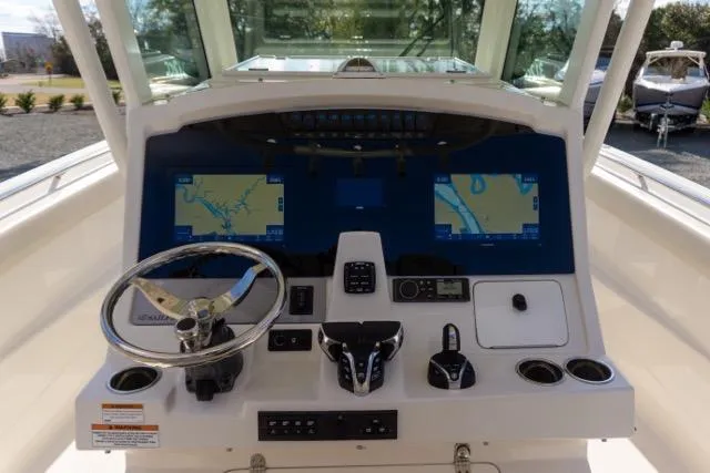 Slide: The Image of 2024 Sailfish 312 CC boat dashboard with dual navigation screens and steering wheel. - 22
