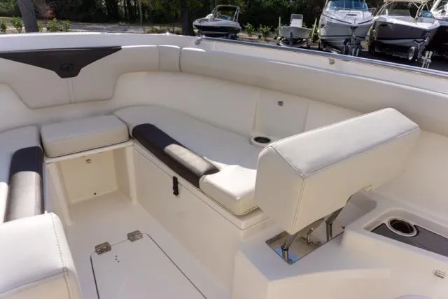 Slide: The Image of 2024 Sailfish 312 CC boat interior with white seating and cup holders. - 28