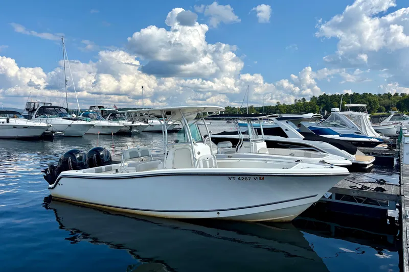 Slide: The Image of 2019 Mako 234 Center Console boat docked at marina under blue sky. - 0