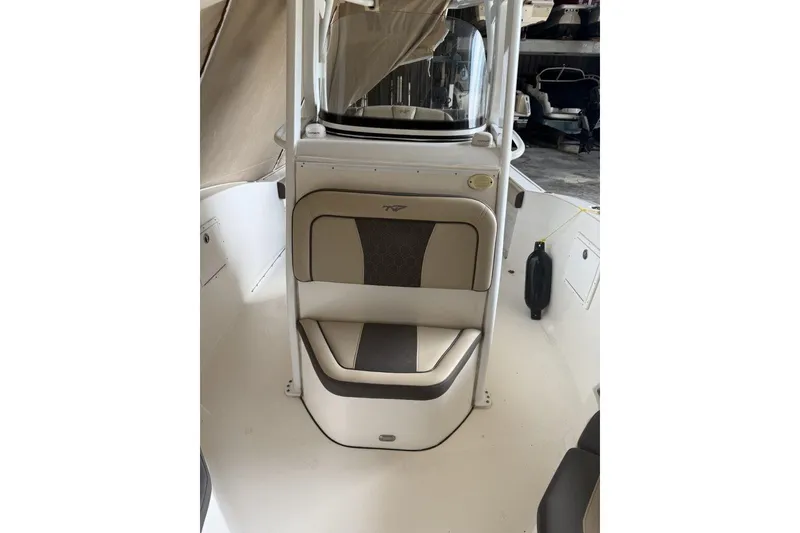 Slide: The Image of 2018 Tidewater 252 CC Adventure boat interior with cushioned seating and console. - 11