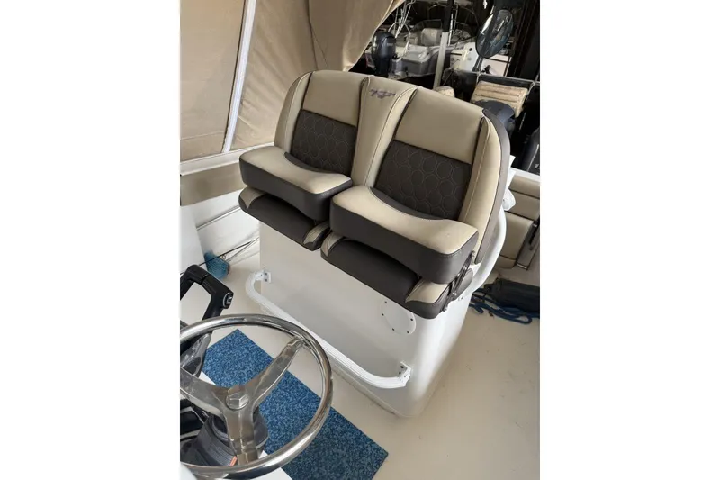 Slide: The Image of 2018 Tidewater 252 CC Adventure boat seats and steering wheel in cockpit view. - 8