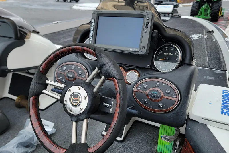 Slide: The Image of Dashboard of a 2010 Triton 20XS DC boat with steering wheel and navigation system. - 12