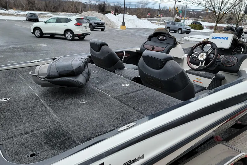 Slide: The Image of 2010 Triton 20XS DC boat interior with steering wheel and seats in parking lot. - 14