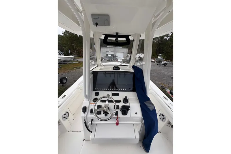 Slide: The Image of 2021 Regulator 28 Forward Seating boat dashboard with steering wheel and navigation equipment. - 6