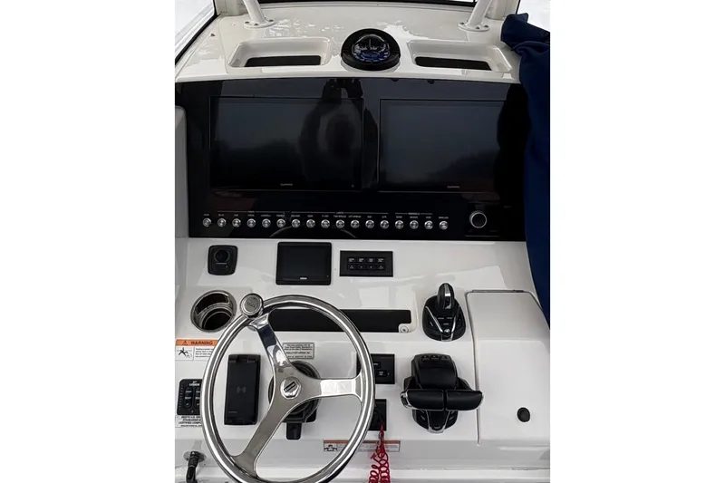 Slide: The Image of 2021 Regulator 28 Forward Seating boat dashboard with steering wheel and control panel. - 7